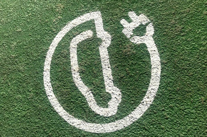 Electric charging symbol for vehicles on green ground