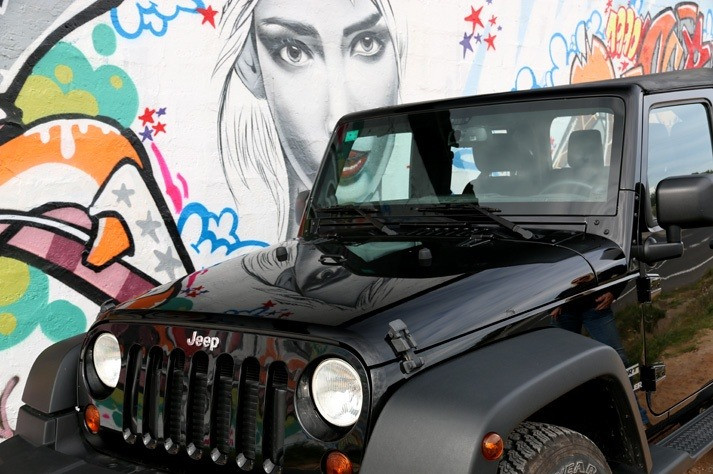 Black Jeep Wrangler rental in Ibiza with graffiti background